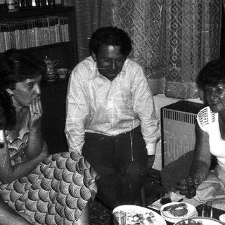 Family gathering around a table eating indoors.