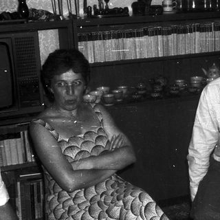 Two people sitting indoors, engaged in conversation.
