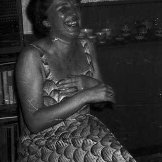 Two people laughing together indoors.
