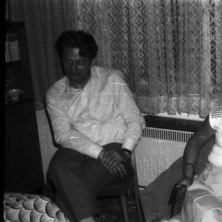 Two elderly individuals sitting indoors together.