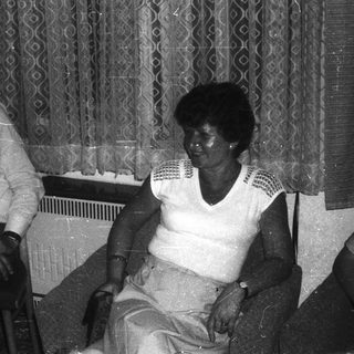 Two elderly individuals sitting indoors together.