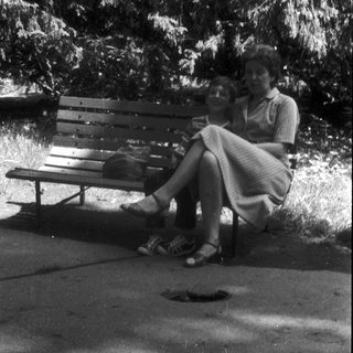 Two people sitting together on a park bench.