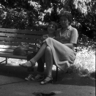 Two people sitting together on a park bench.