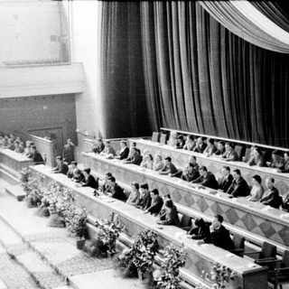 Historic conference or assembly hall with delegates seated.
