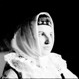 Woman in traditional headscarf and lace collar.