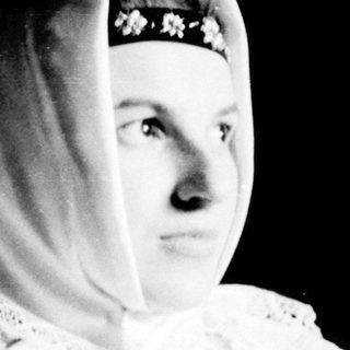 Woman in traditional headscarf and lace collar.