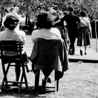 Group of people playing outdoor lawn games.