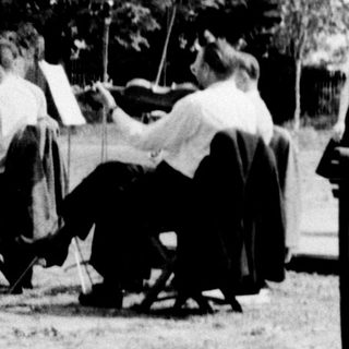 Group of people playing outdoor lawn games.