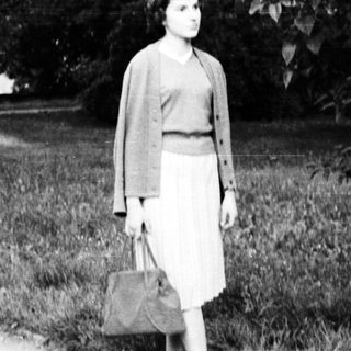 Young woman walking outdoors in vintage dress.
