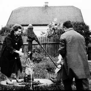 Two people inspecting an old water well.