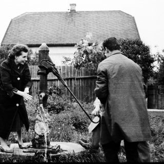 Two people inspecting an old water well.