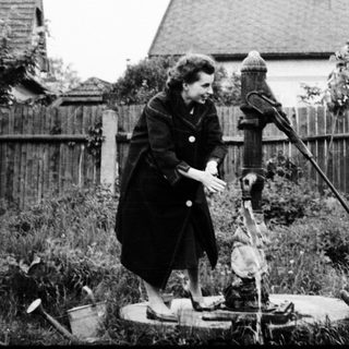 Two people inspecting an old water well.