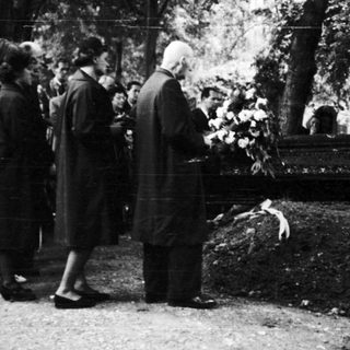 People gathered at a gravesite in a cemetery.