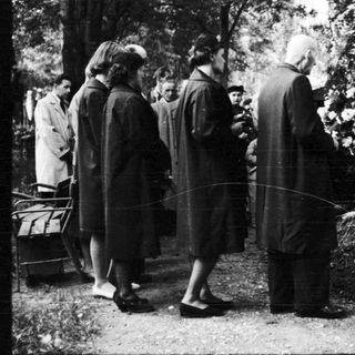 People gathered at a gravesite in a cemetery.