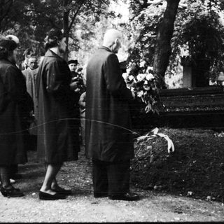 People gathered at a gravesite in a cemetery.