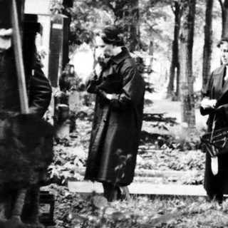 Traditional funeral gathering at a cemetery.