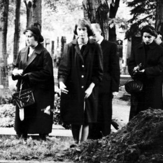 Traditional funeral gathering at a cemetery.