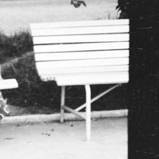 A woman sitting on a bench outdoors.
