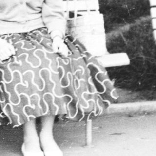 A woman sitting on a bench outdoors.