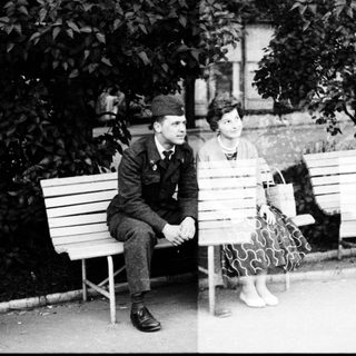 Two people sitting on park benches, likely mid-20th century.