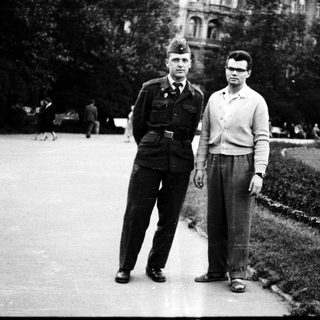 Two men posing outdoors in military and casual attire, mid-20th century.