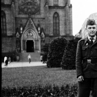 Couple posing in 1940s military uniform and stylish attire.