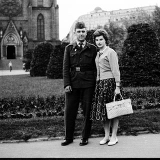 Couple posing in 1940s military uniform and stylish attire.
