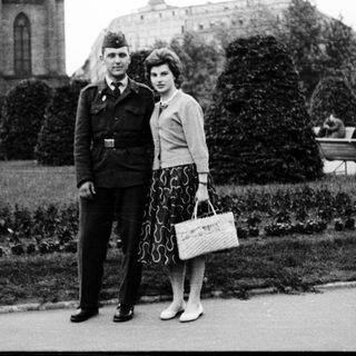 Couple posing in 1940s military uniform and stylish attire.