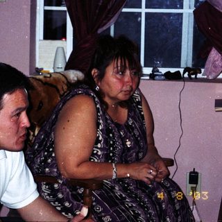 Two people sitting indoors, appearing distressed.