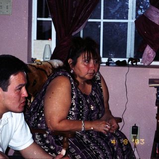 Two people sitting indoors, appearing distressed.