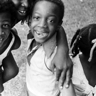Three joyful children posing happily outdoors.