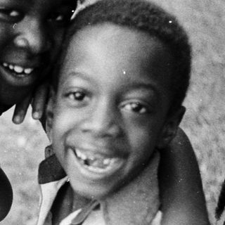 Three joyful children posing happily outdoors.