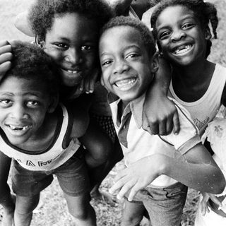 Five joyful children posing happily outdoors.
