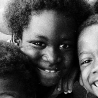 Five joyful children posing happily outdoors.