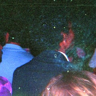 Crowded indoor event with blacklight and star-shaped marker.