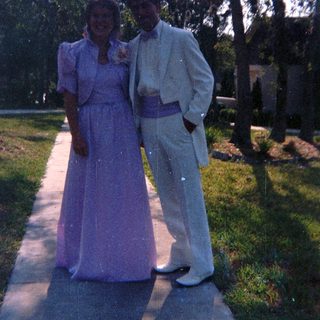 Prom attire in outdoor garden setting.