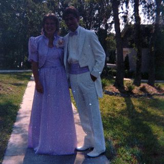 Prom attire in outdoor garden setting.