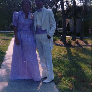 Couple dressed in formal attire outdoors.