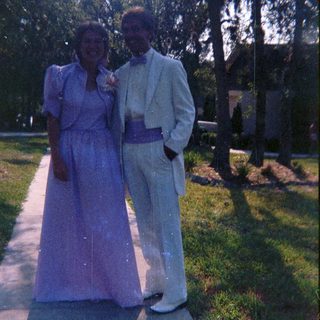 Couple dressed in formal attire outdoors.