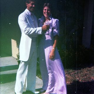 Two people posing together outdoors at night.