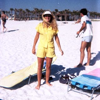 Sunny beach scene with woman in yellow outfit.