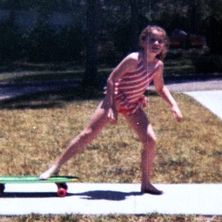 Young child skateboarding on pavement.