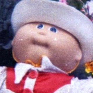 Scarecrow dressed as baby in garden.