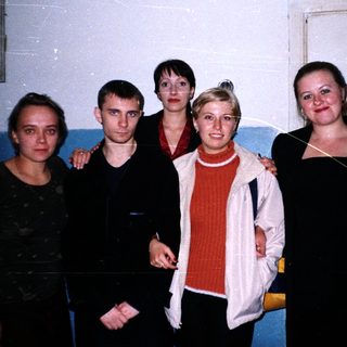 Group of five people standing near a doorway.