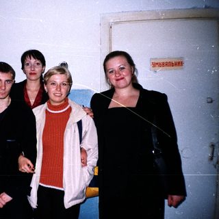 Group of five people standing near a doorway.
