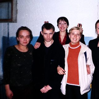 Group of five people standing near a door.