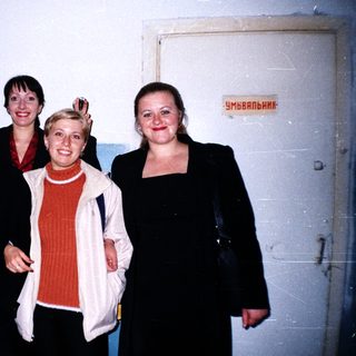 Group of five people standing near a door.