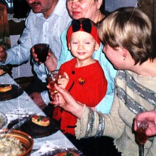Family gathers for a meal with food and drinks.