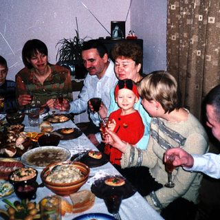 Family gathers for a meal with food and drinks.