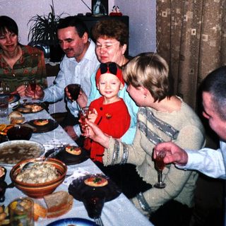 Family gathers for a meal with food and drinks.